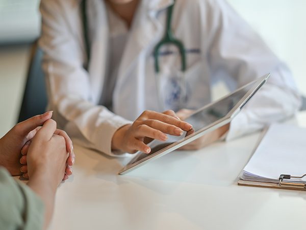 Shot of a doctor showing a patient some information on a digital tablet